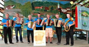 OL  Sverjanski muzikanti  so svirali in se slikali s praporom upokojencev katerih člani so tudi sami  F JM (2)